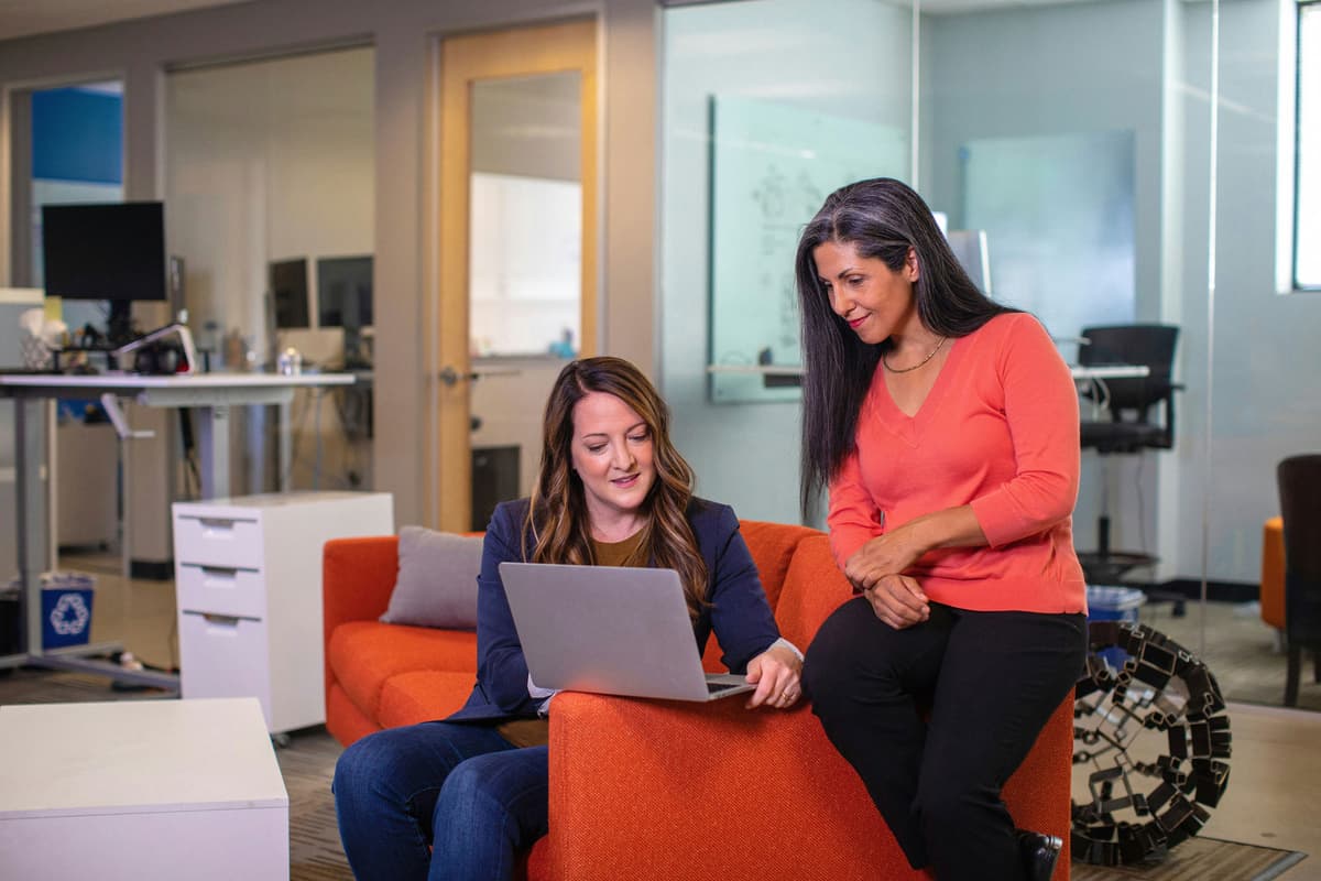 Two women looking at a laptop in an office